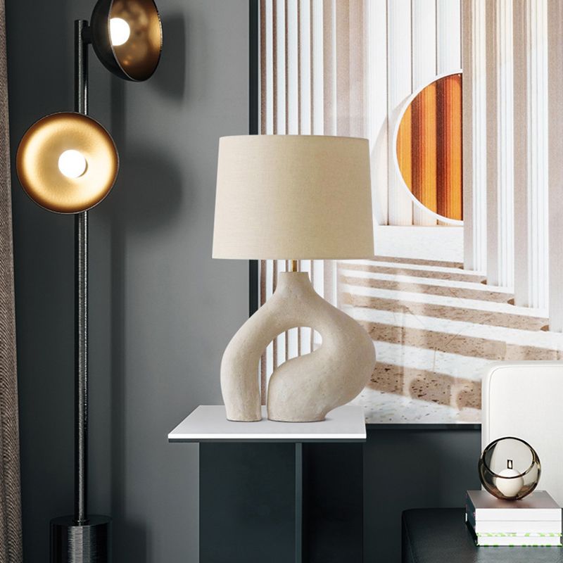 Stylish white lamp illuminating a cozy bedroom setting.