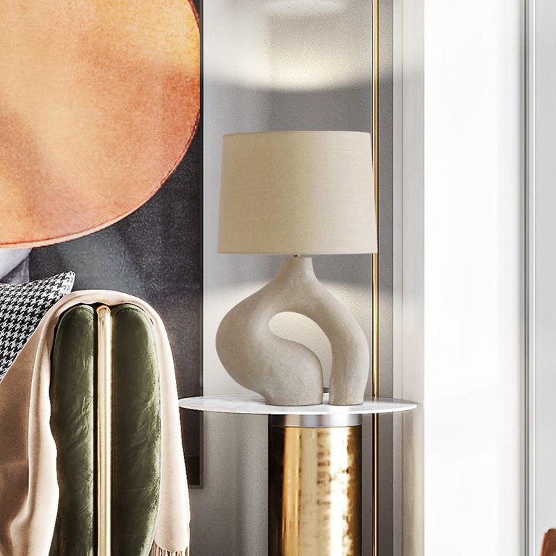 Elegant white resin table lamp showcasing its fabric shade and modern design.