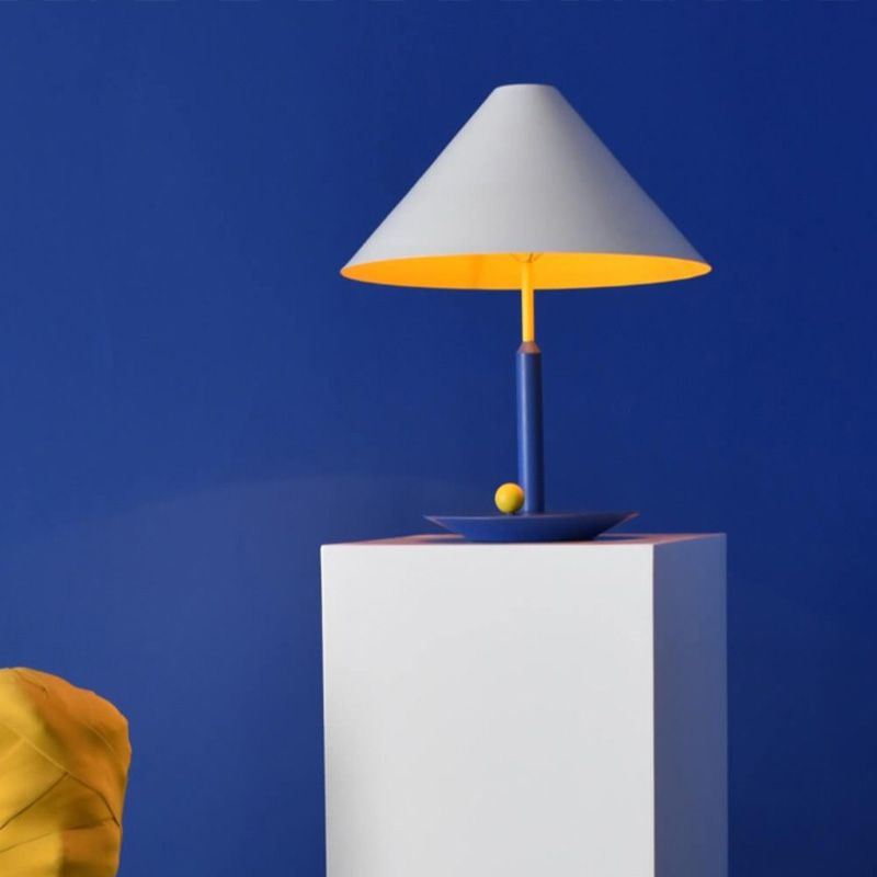 Elegant modern cone table lamp showcasing its stylish fabric shade in a cozy living room setting.