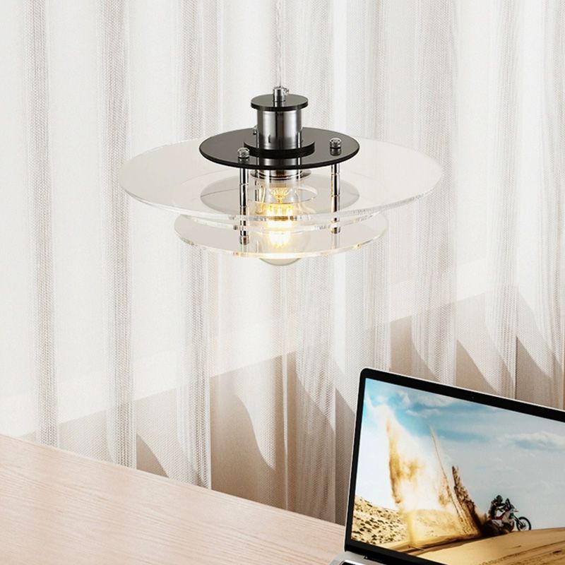 Side view of the LucentForm acrylic pendant light hanging above a minimalist dining table
