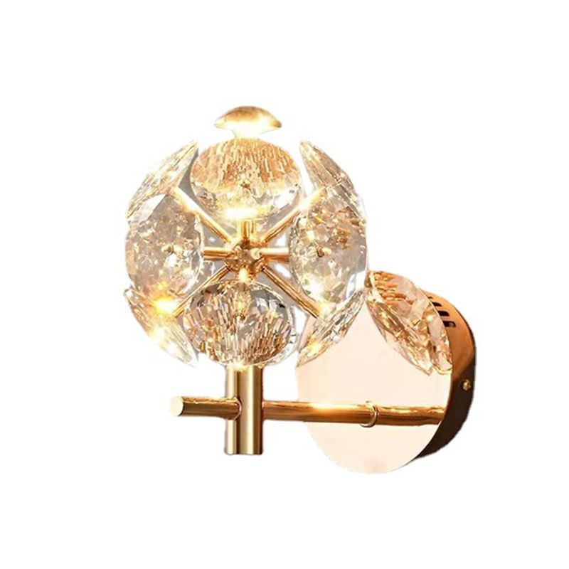 Close-up of the modern gold wall lamp featuring a clear crystal shade.