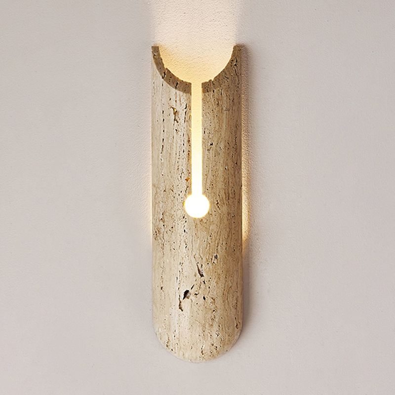 Beige stone shade wall sconce mounted in a cozy bedroom setting