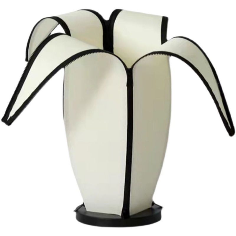 Front view of charming banana-shaped modern table lamp on a bedside table.