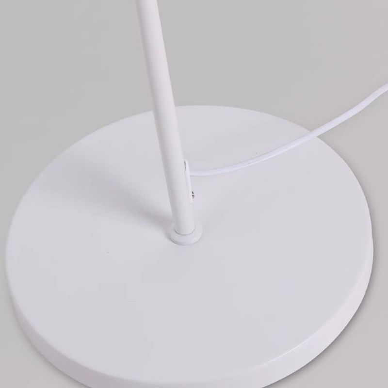 Elegant white metal floor lamp with dome shade in a cozy living room setting.