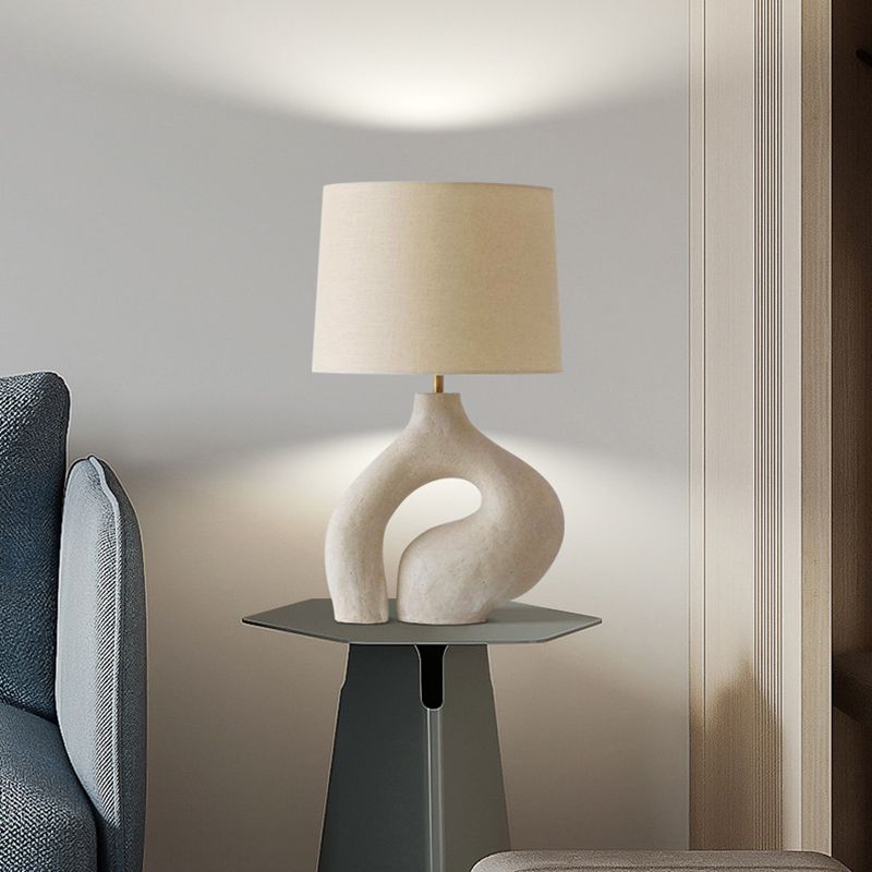 Elegant white resin table lamp showcasing its fabric shade and modern design.