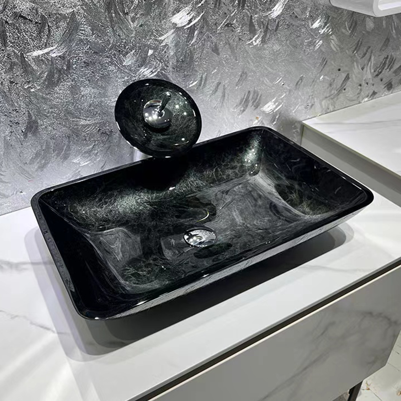 Elegant gray black round tempered glass wash basin with droplet faucet.