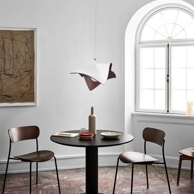 The Nordic wooden pendant light illuminating a modern dining area, enhancing the decor.
