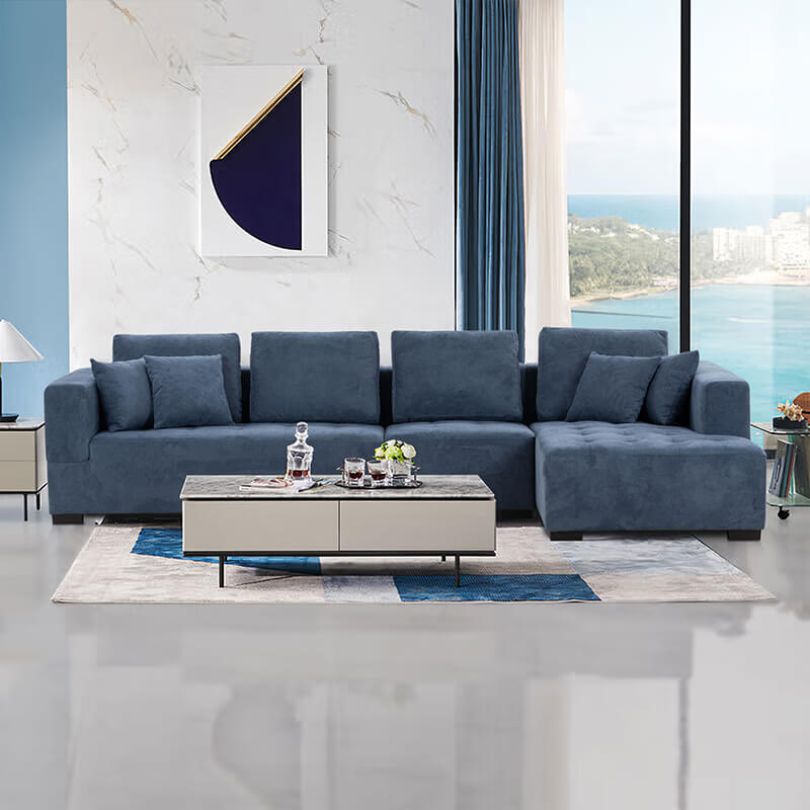 Mid-century blue linen sectional sofa viewed from the side, highlighting the chaise and cushioning.
