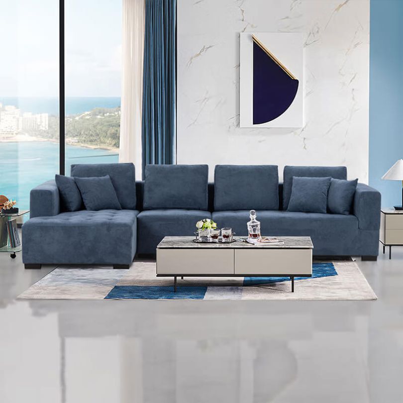 L-shaped sofa in a modern living room setting, highlighting its blue fabric and left chaise