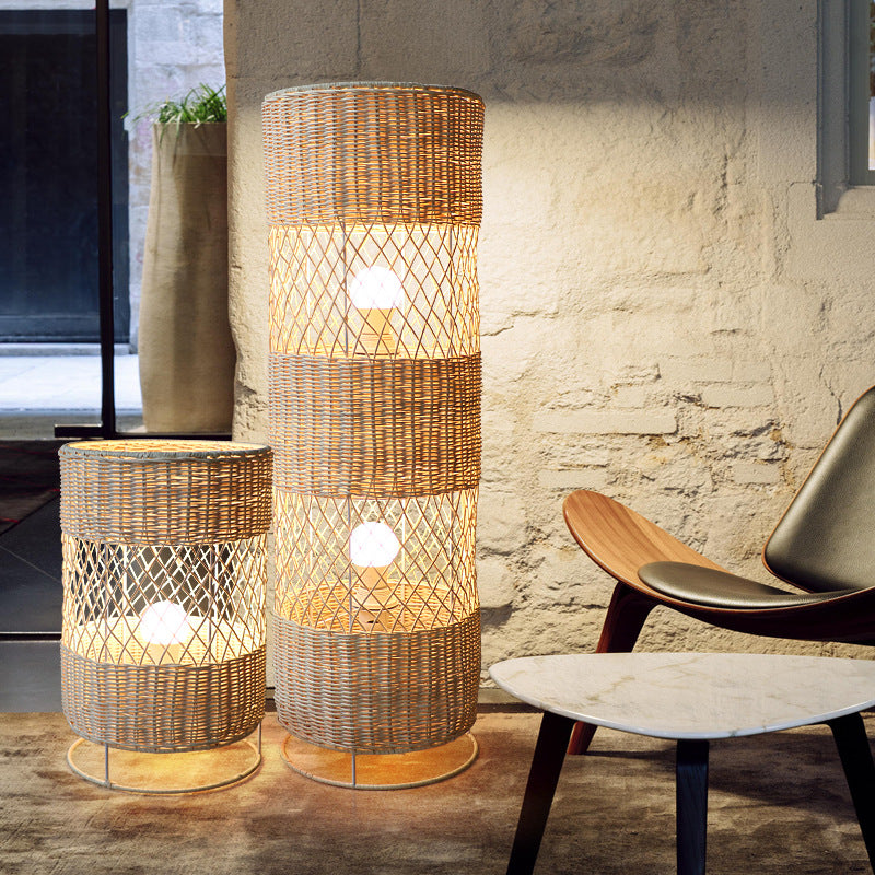 The rattan floor lamp lit up in a cozy living room, emphasizing its warm ambiance and stylish look.