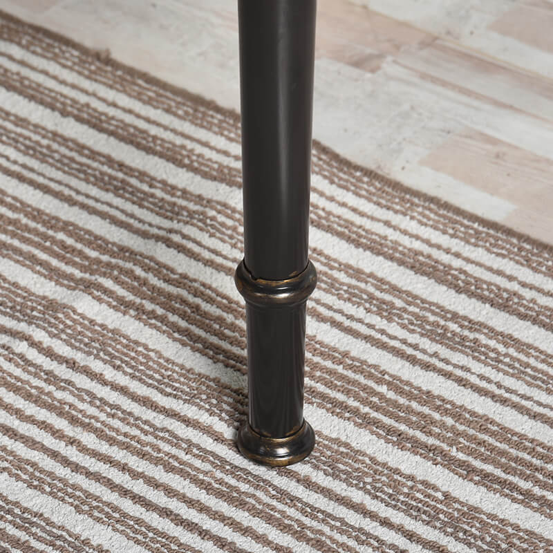 Close-up of the antique ring detail on the legs of the modern wood table, highlighting craftsmanship.