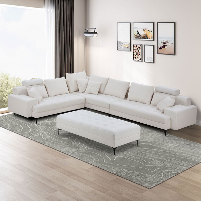 Luxurious off white reversible sectional sofa with ottoman in a contemporary living room.