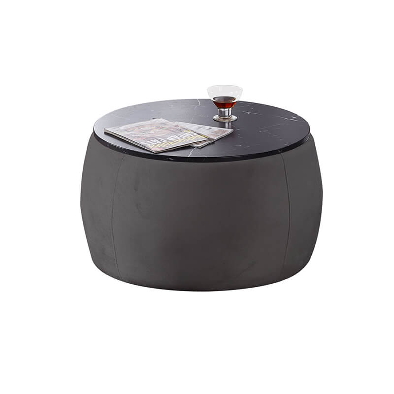 View of the black round storage ottoman coffee table in a cozy living room setting, highlighting storage capability.