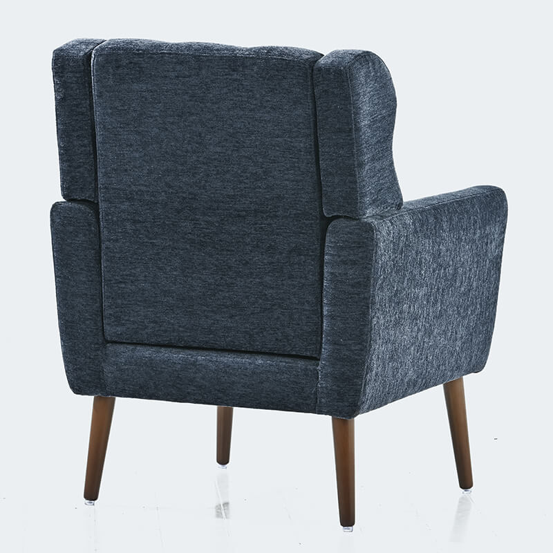Comfortable dark blue upholstered chair used for reading in a cozy corner.