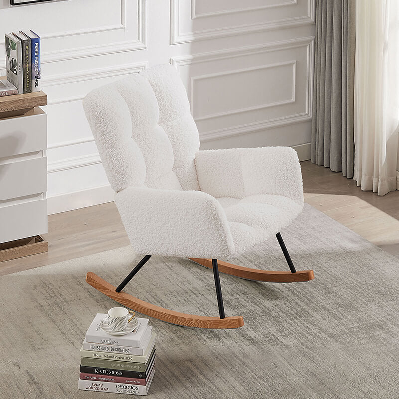 View of the beige upholstered rocking chair with high backrest in a bright nursery setting.