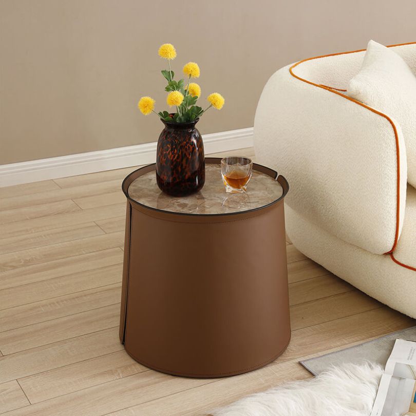 Elegant saddle leather coffee table with brown marble top, showcasing the round shape and luxurious finish.
