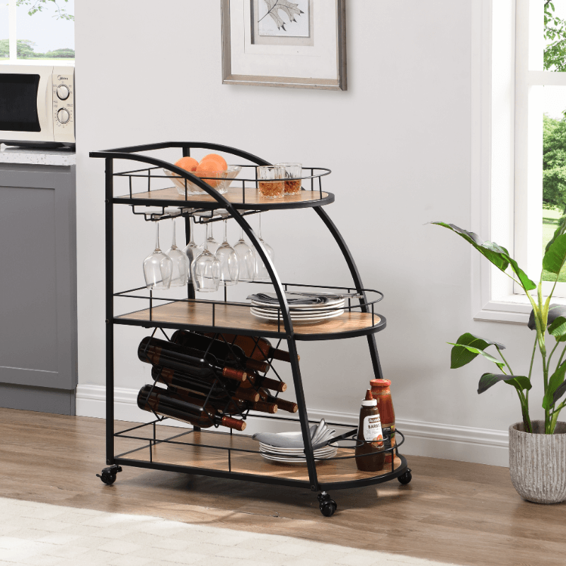 Angled view of modern bar cart with wheels and shelves, fully stocked with wine and glassware