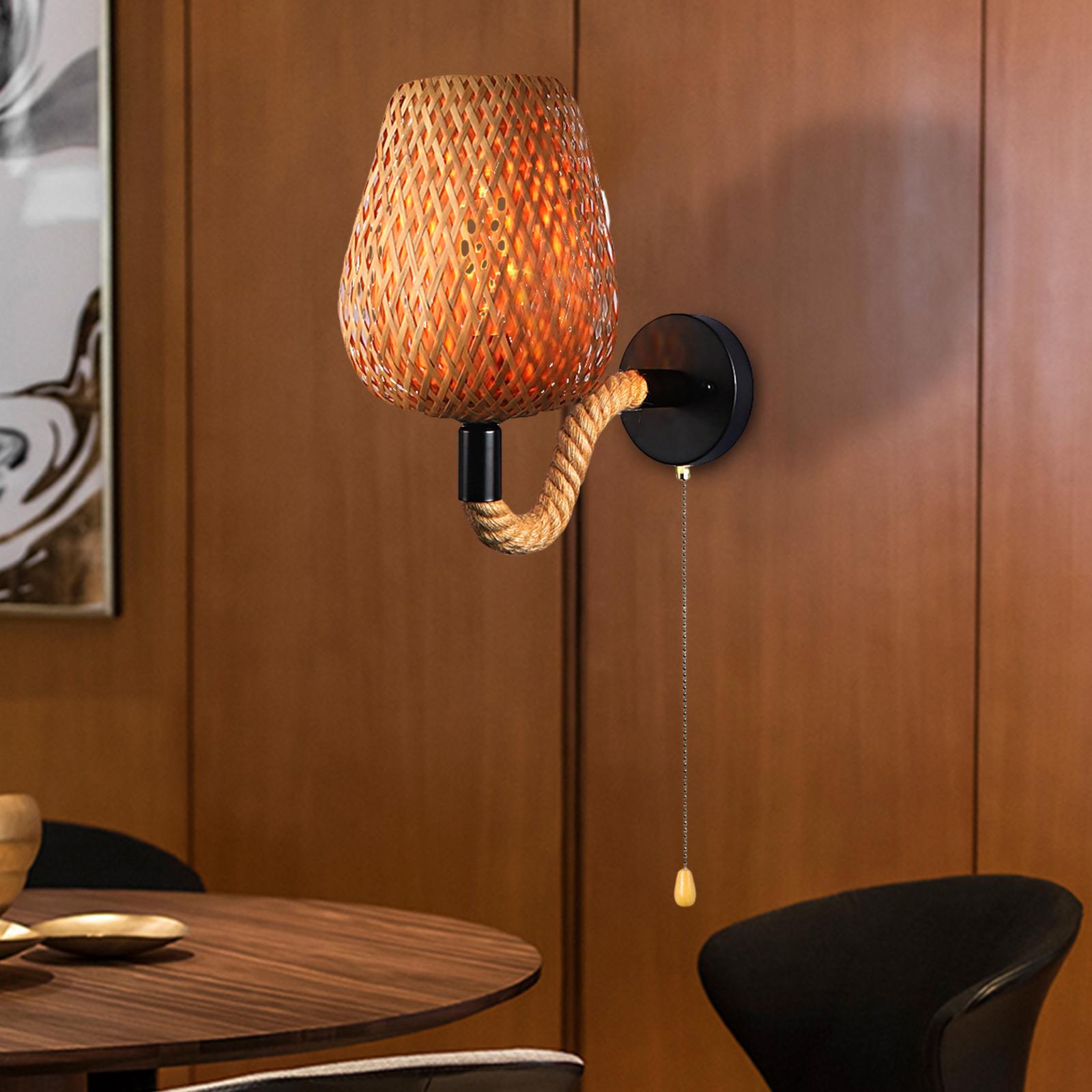Close-up of hemp rope handle and woven rattan shade of rustic wall fixture