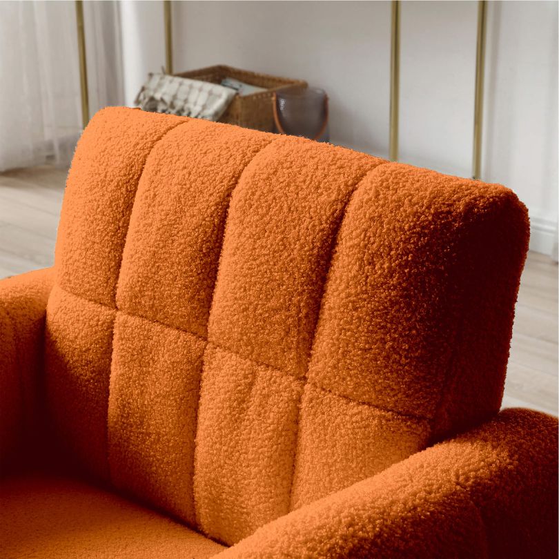 Vibrant orange tufted accent chair with gold accents in a cozy living room setting.