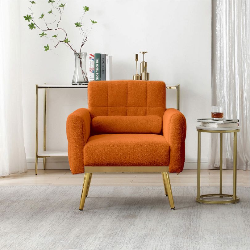 Vibrant orange tufted accent chair with gold accents in a cozy living room setting.
