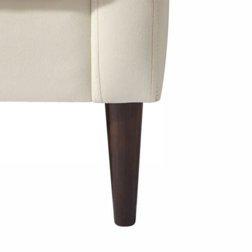 Close-up view of the tufted fabric and armrests on the elegant white accent chair