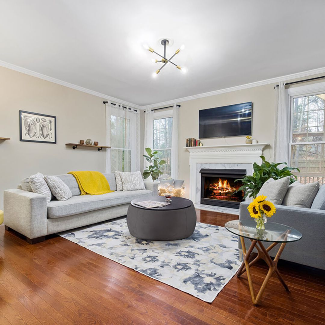 View of the black round storage ottoman coffee table in a cozy living room setting, highlighting storage capability.