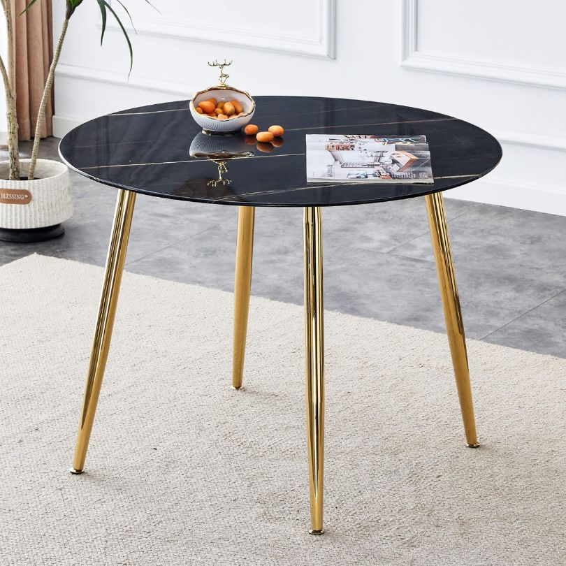 Elegant black dining table with gold accents, showcasing its round shape and luxurious design.