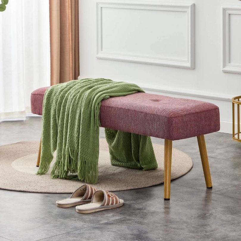 Side angle of the modern pink upholstered bench, highlighting its soft fabric and sturdy construction.