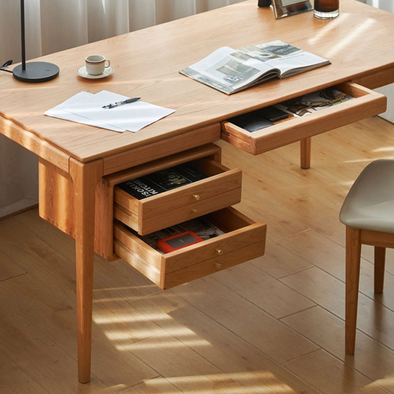 Cherry wood writing desk with drawers, showcasing sleek Scandinavian design.