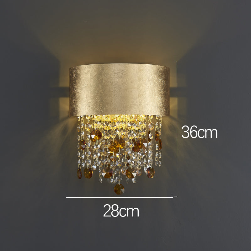 Elegant gold crystal teardrop wall sconce showcasing its luxurious design in a modern dining room.