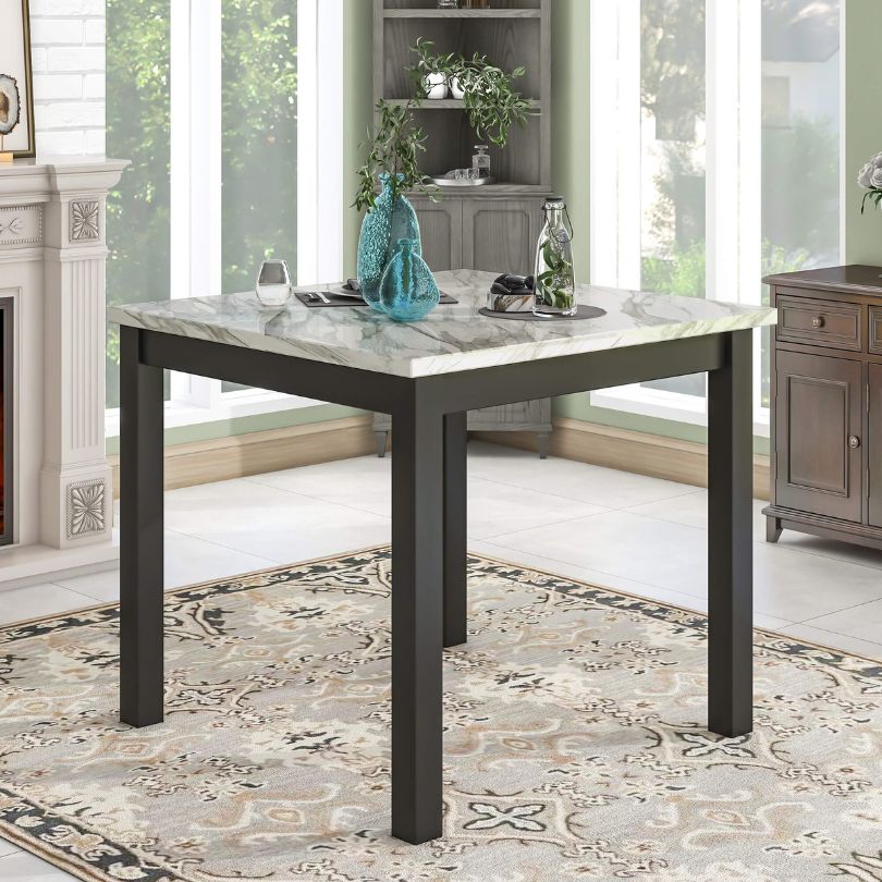 Elegant counter height dining table set showcasing four blue upholstered chairs and a faux marble table from the side view.