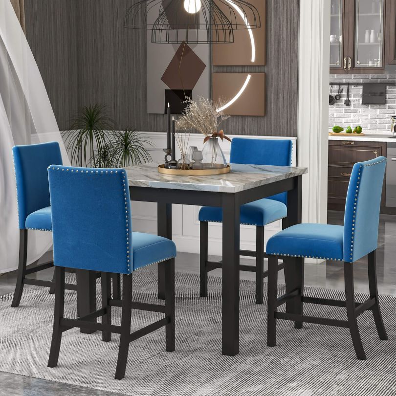 Close-up of the stylish blue upholstered chairs paired with a sturdy faux marble dining table in a modern kitchen setting.