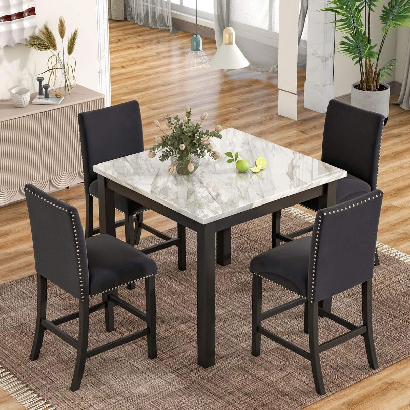 Close-up of the faux marble dining table with four black upholstered chairs, highlighting its elegant design.