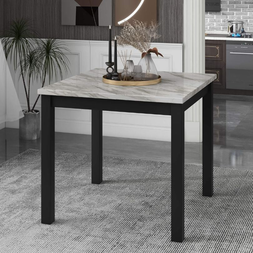 Close-up of the faux marble dining table with four black upholstered chairs, highlighting its elegant design.