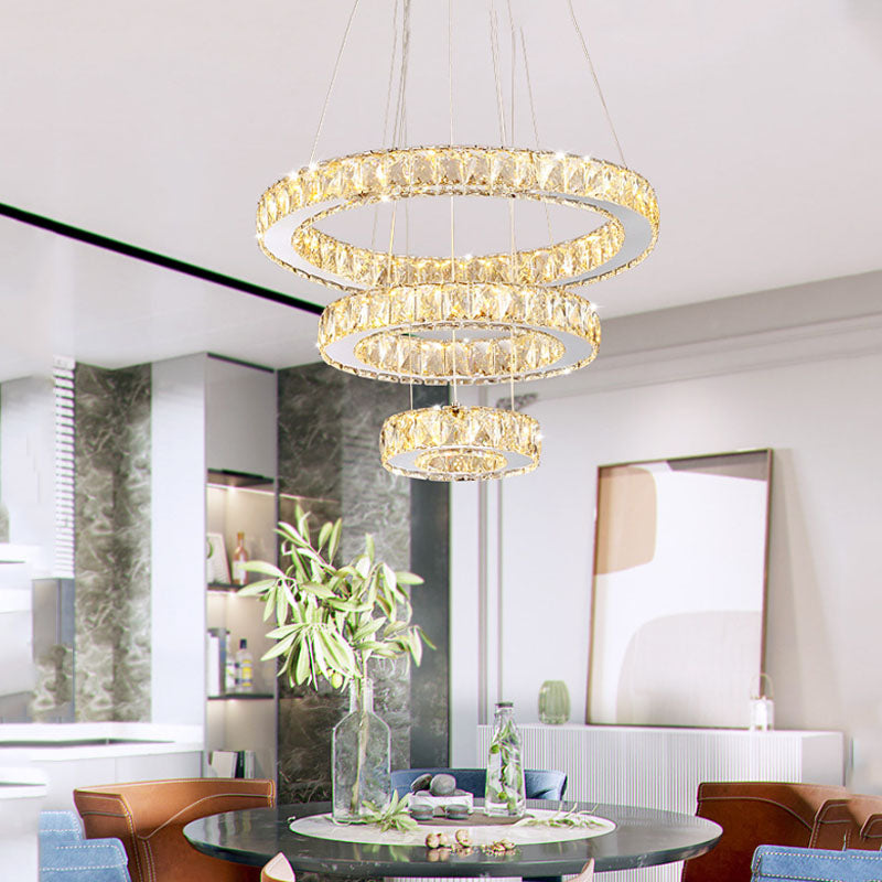 Elegant 3-ring crystal LED pendant light in a contemporary dining room setting.