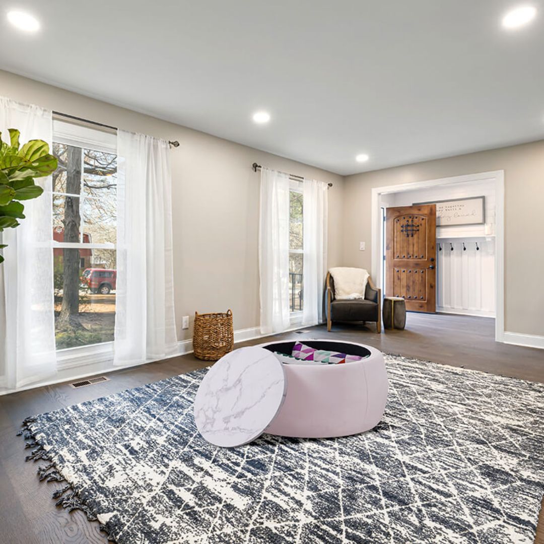 Top view of the pink round storage ottoman with wooden lid open, revealing storage space.
