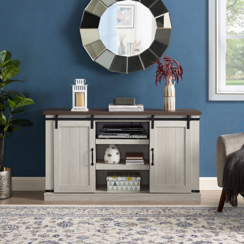 Front view of rustic 60-inch light gray TV stand with sliding barn doors and open shelf.