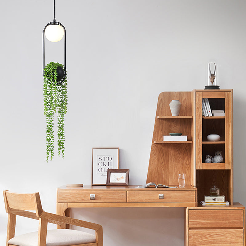 View of the pendant light installed in a cozy bedroom corner with vibrant plants.