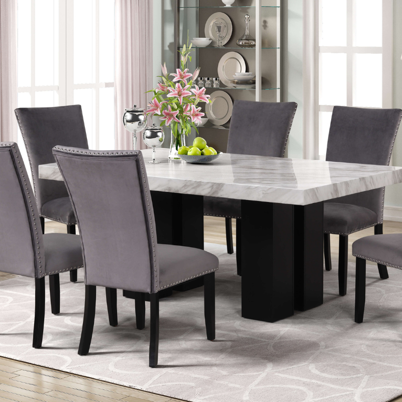 Luxurious faux marble dining table set showcasing gray velvet chairs from an angled perspective.