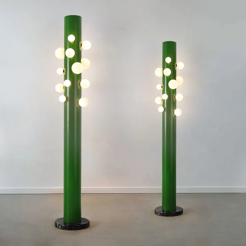 Close-up of the base and fluted vertical structure of the green cylinder glass floor lamp.