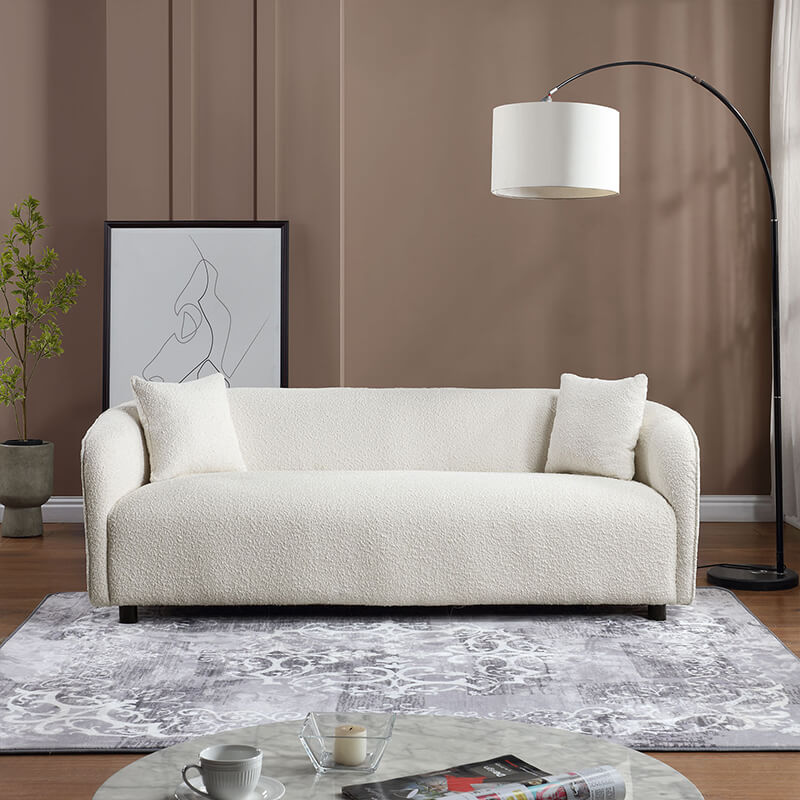 Elegant beige curved sofa from the side, showcasing its modern design in a stylish living room