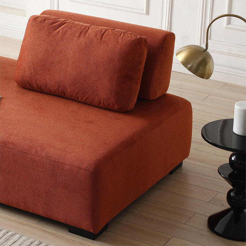 Side angle of the modular orange sofa in a stylish living room setting, demonstrating its versatility.