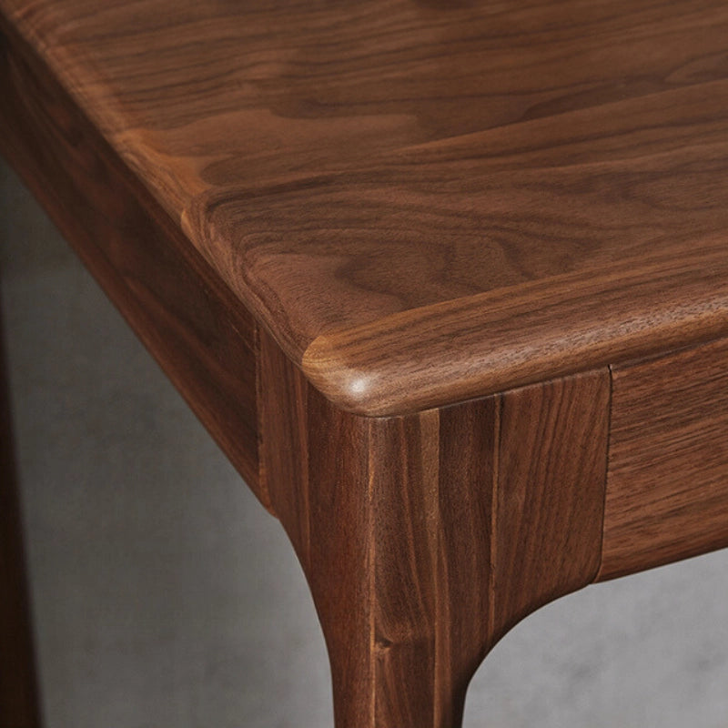 Close-up of the walnut desks smooth finish and drawer details, highlighting its quality craftsmanship.