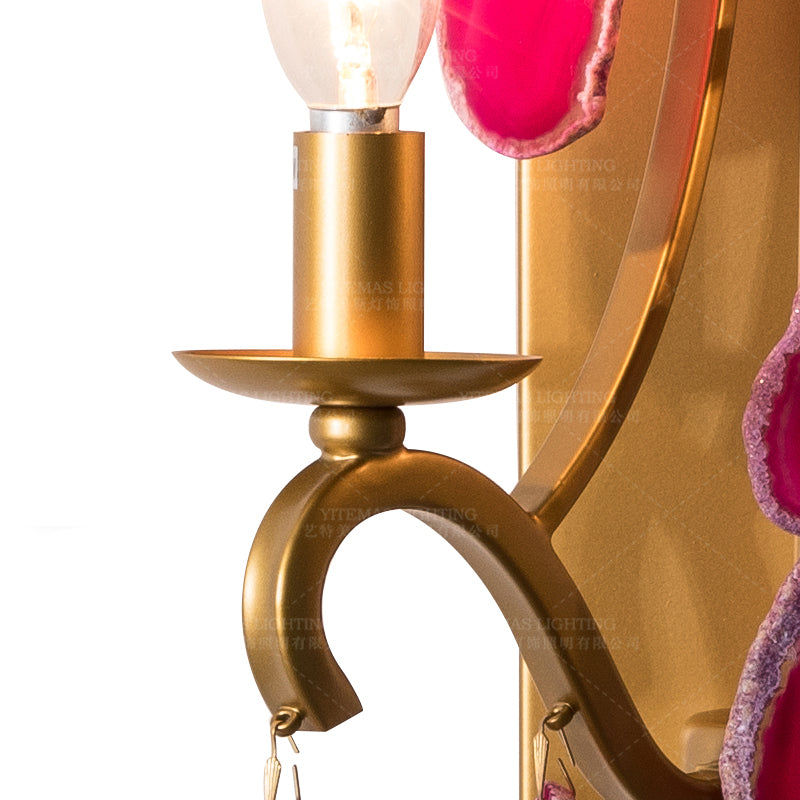 Art Deco style pink agate wall lamp illuminating a modern dining area.
