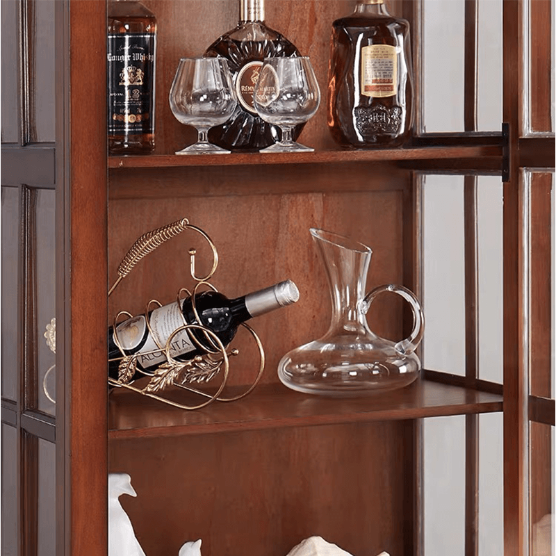Close-up of the glass door detail on the antique wine cabinet, emphasizing craftsmanship and design.