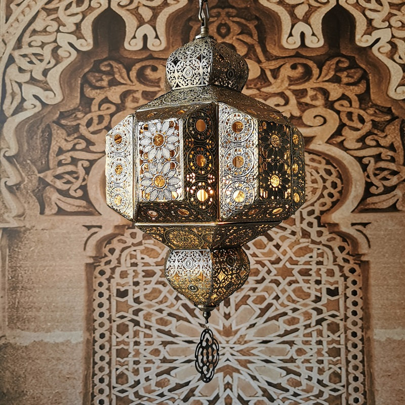 Moroccan pendant light illuminating a cozy bedroom, highlighting its unique design.