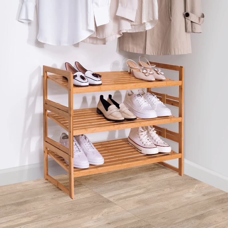 Natural bamboo shoe organizer displaying various shoes in a modern entryway.