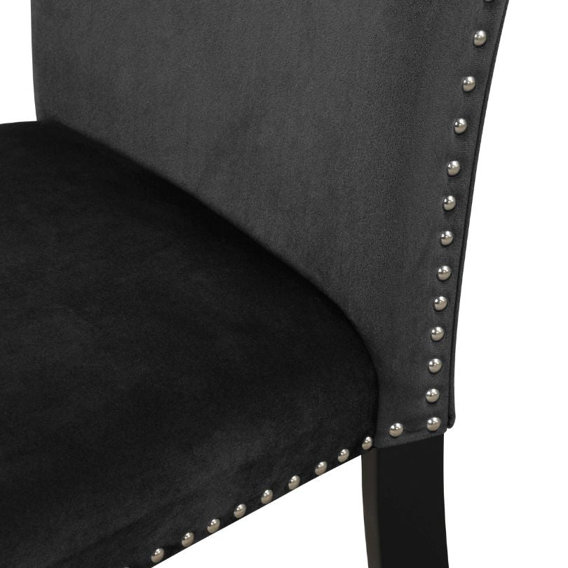 Stylish black velvet dining chair set placed around a modern dining table.
