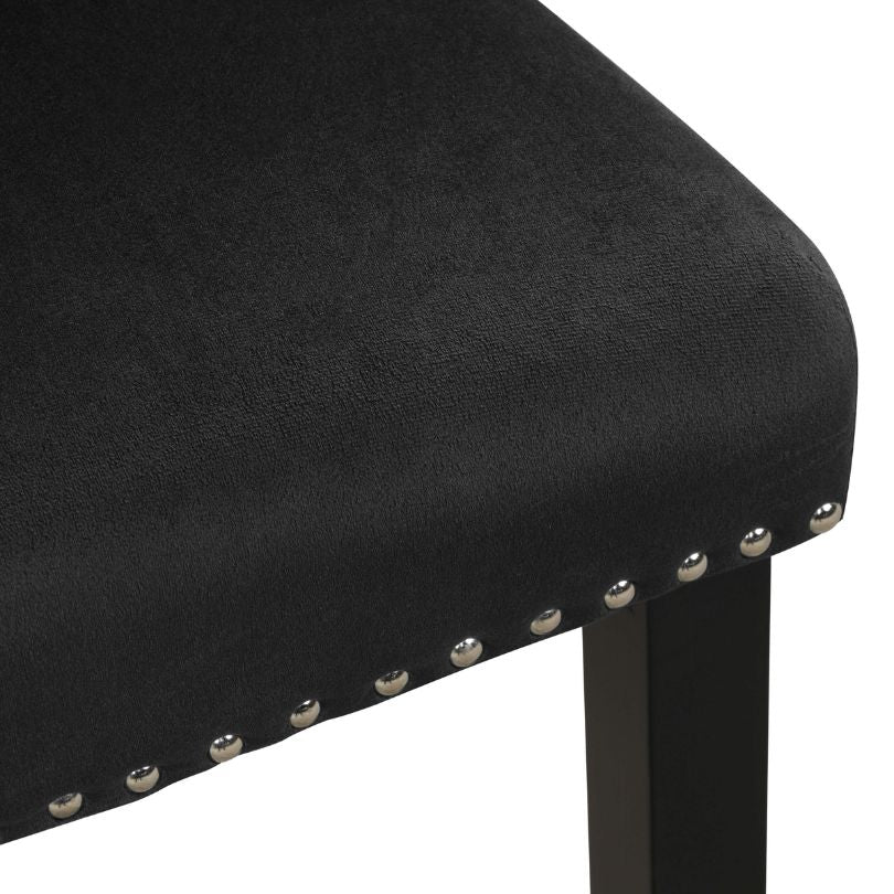 Elegant black velvet armless dining chair set showcasing nailhead trim from the side.