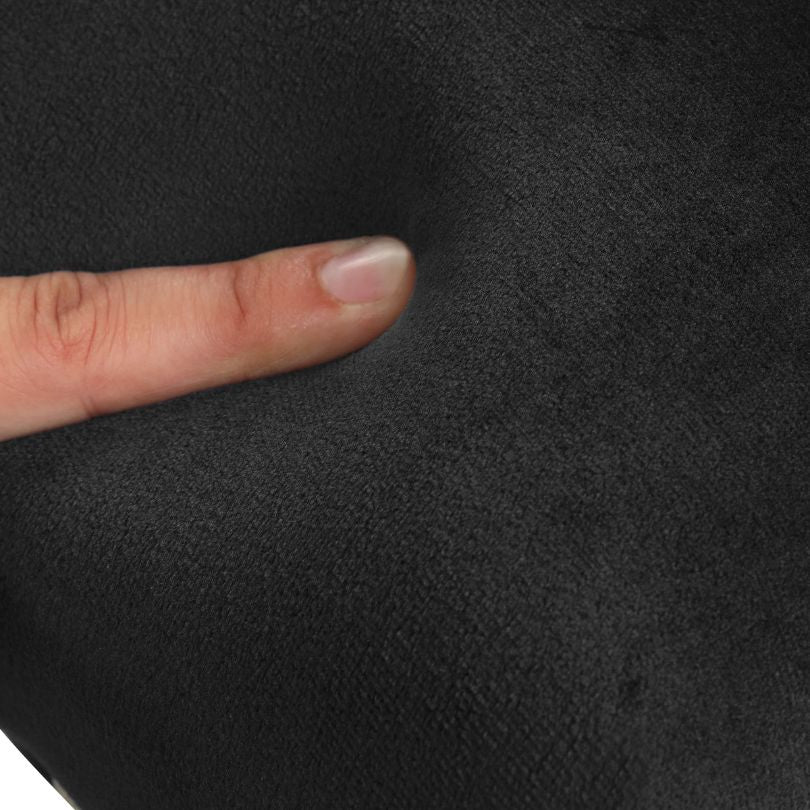 Close-up view of black velvet chair upholstery and rubber wood legs.